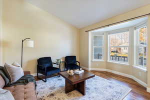 Living room with vaulted ceiling and hardwood / wood-style flooring