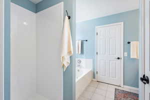 Bathroom with tile patterned flooring and a washtub