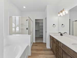 Bathroom featuring plus walk in shower, hardwood / wood-style floors, and vanity