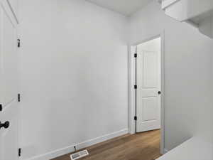 Hallway with hardwood / wood-style floors