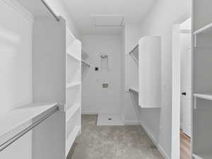 Walk in closet with light carpet