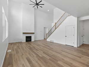 Unfurnished living room with ceiling fan, a textured ceiling, and light hardwood / wood-style flooring