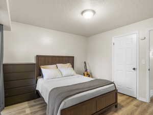 Bedroom featuring a textured ceiling and light wood-type flooring