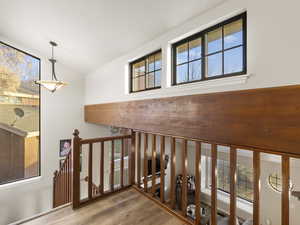 Stairway featuring hardwood / wood-style floors, a healthy amount of sunlight, and vaulted ceiling