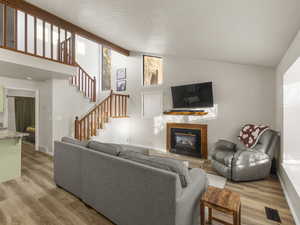 Living room featuring beam ceiling, high vaulted ceiling, and light hardwood / wood-style flooring