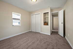 Unfurnished bedroom with carpet flooring and a closet