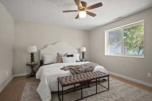 Carpeted bedroom featuring a textured ceiling and ceiling fan