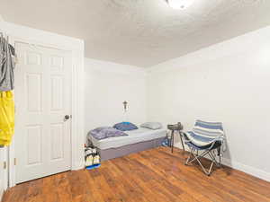 Bedroom with wood-type flooring and a textured ceiling