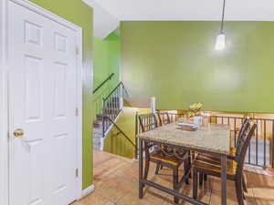 Dining room featuring light tile patterned flooring and vaulted ceiling