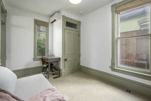 Bedroom featuring light colored carpet and a wall mounted AC