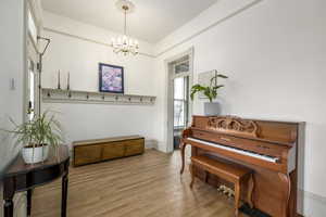 Miscellaneous room with light hardwood / wood-style floors and an inviting chandelier