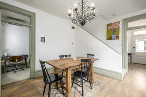 Dining space with an inviting chandelier and light wood-type flooring