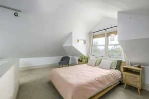 Carpeted bedroom with lofted ceiling