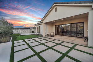 Back house at dusk featuring a patio