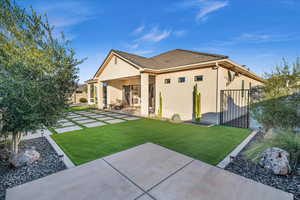 Back of house with a lawn and a patio area