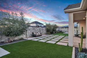 Yard at dusk with a patio and an outdoor hangout area