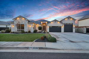 View of front of property featuring a garage and a lawn