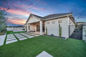 Back house at dusk featuring a mountain view and a patio