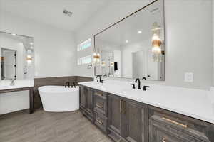 Bathroom featuring a washtub and vanity