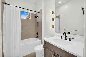 Full bathroom featuring tile patterned flooring, vanity, toilet, and shower / tub combo with curtain