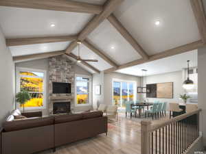 Living room featuring vaulted ceiling with beams, a fireplace, ceiling fan with notable chandelier, and light wood-type flooring