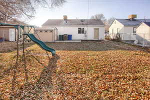 Rear view of house featuring a playground