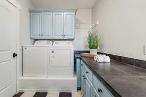 Laundry area featuring cabinets and washing machine and clothes dryer