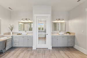 Bathroom featuring hardwood / wood-style floors, vanity, and a tub to relax in