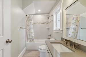 Full bathroom with shower / bath combination with curtain, vanity, hardwood / wood-style flooring, and toilet