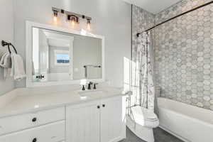 Full bathroom with tile patterned floors, vanity, toilet, and shower / tub combo