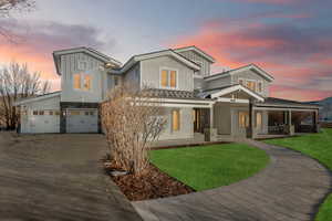 View of front of home featuring a garage, covered porch, and a yard