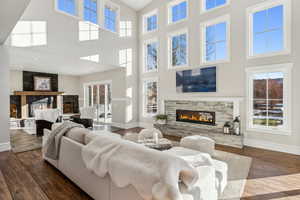 Living room featuring a towering ceiling and dark wood-type flooring