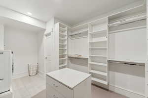 Walk in closet with light tile patterned floors and washer / clothes dryer