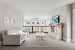 Living room with light carpet, vaulted ceiling, and ceiling fan