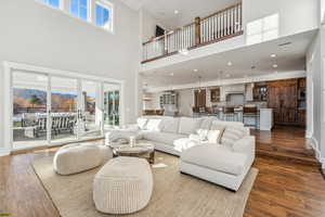 Living room featuring a towering ceiling and dark wood-type flooring