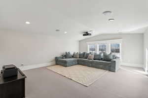 Cinema with carpet flooring and lofted ceiling