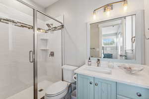 Bathroom with toilet, vanity, and walk in shower