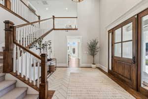 Entryway with plenty of natural light, light parquet flooring, and a high ceiling