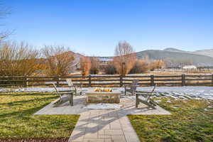 View of yard featuring a mountain view, a patio, and an outdoor fire pit