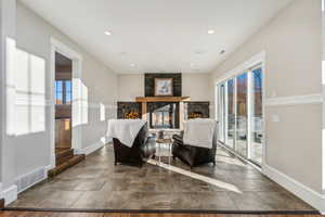 Sitting room featuring a fireplace, dark hardwood / wood-style floors, and a healthy amount of sunlight