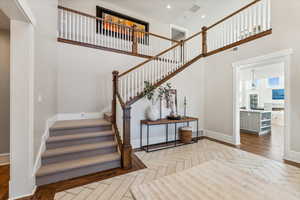 Staircase with parquet flooring and a towering ceiling