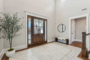 Foyer featuring a high ceiling and light parquet floors