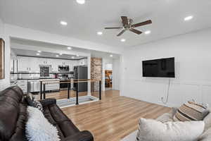 Living room featuring light wood-type flooring and ceiling fan