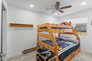 Carpeted bedroom with ceiling fan