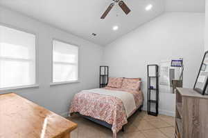 Bedroom featuring light tile patterned floors, ceiling fan, and lofted ceiling