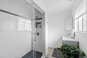 Bathroom featuring vanity, a healthy amount of sunlight, an enclosed shower, and hardwood / wood-style flooring