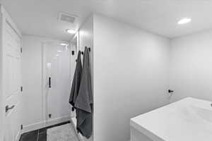 Clothes washing area featuring dark tile patterned floors