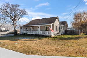 View of front facade with covered porch and a front yard