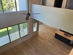 Unfurnished living room featuring light wood-type flooring and ceiling fan