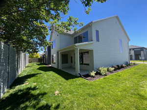 Rear view of house featuring a lawn and a patio area